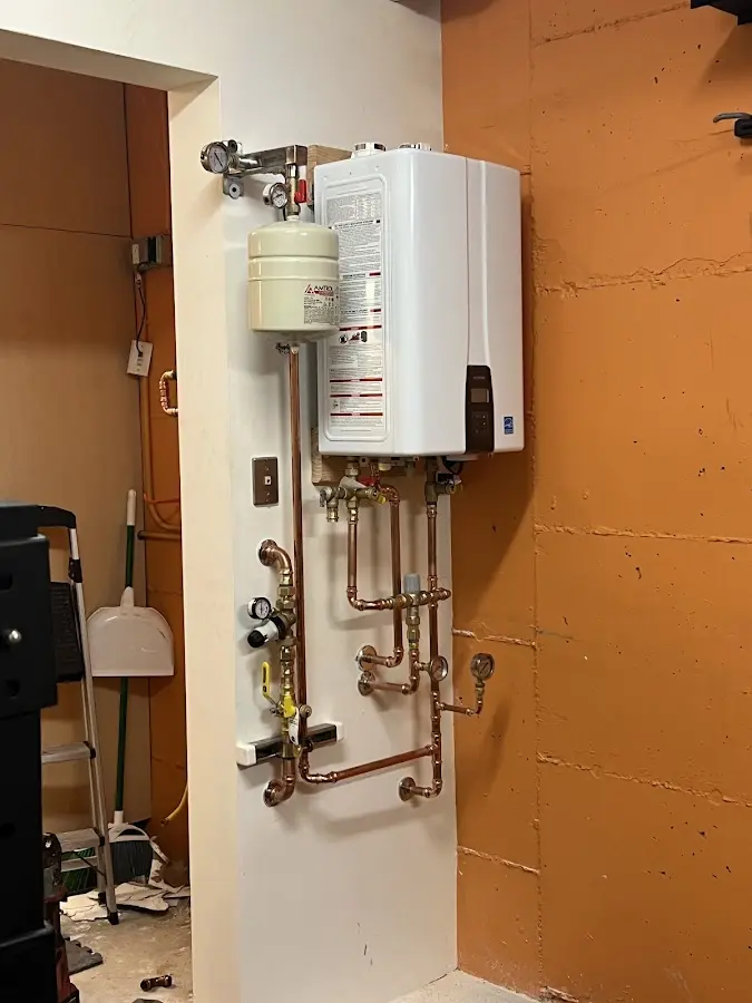 Plumbing technician inspecting water heater connections in Russell